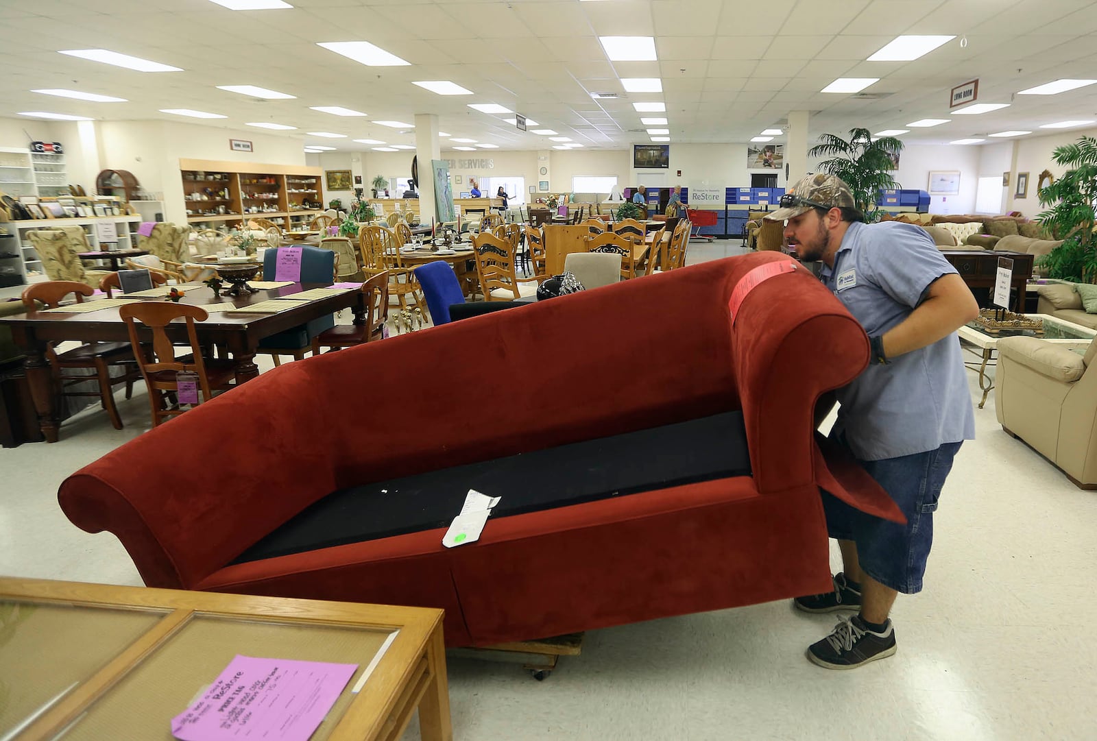Braden Roberts relocates a sofa it in the Habitat for Humanity ReStore in Lake Worth. The store carries items from place mats to kitchen cabinets. (