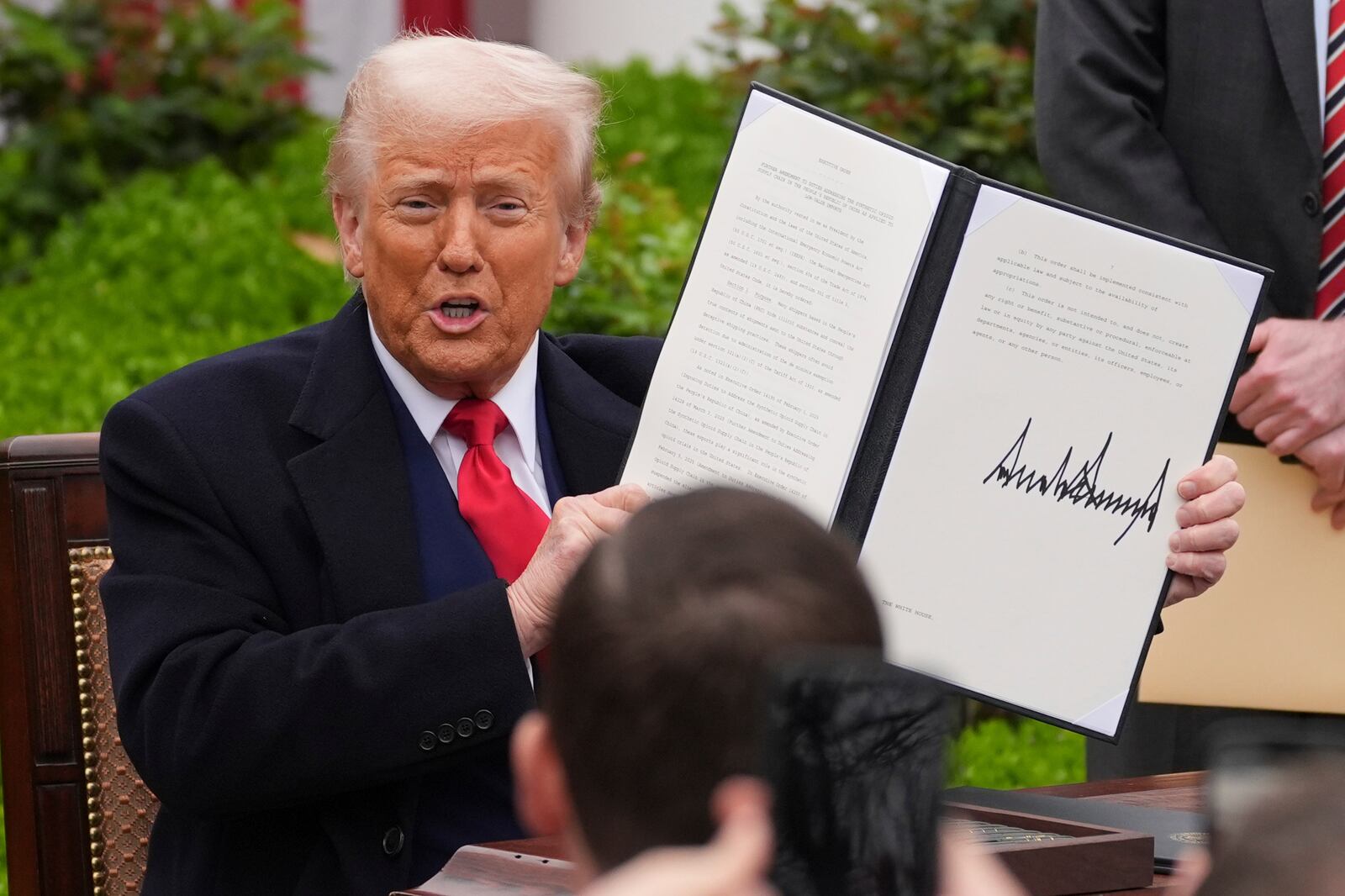 President Donald Trump holds.a signed executive order during an event to announce new tariffs in the Rose Garden of the White House, Wednesday, April 2, 2025, in Washington. (AP Photo/Evan Vucci)