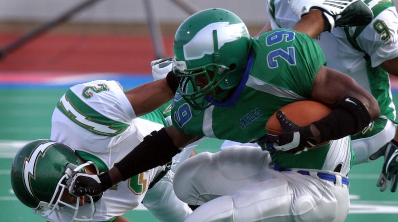 Chaminade-Julienne senior running back Javon Ringer fends off Northmont junior defensive back Kurt Coleman during CJ's 39-36 season-opening win at Welcome Stadium in 2004. FILE PHOTO