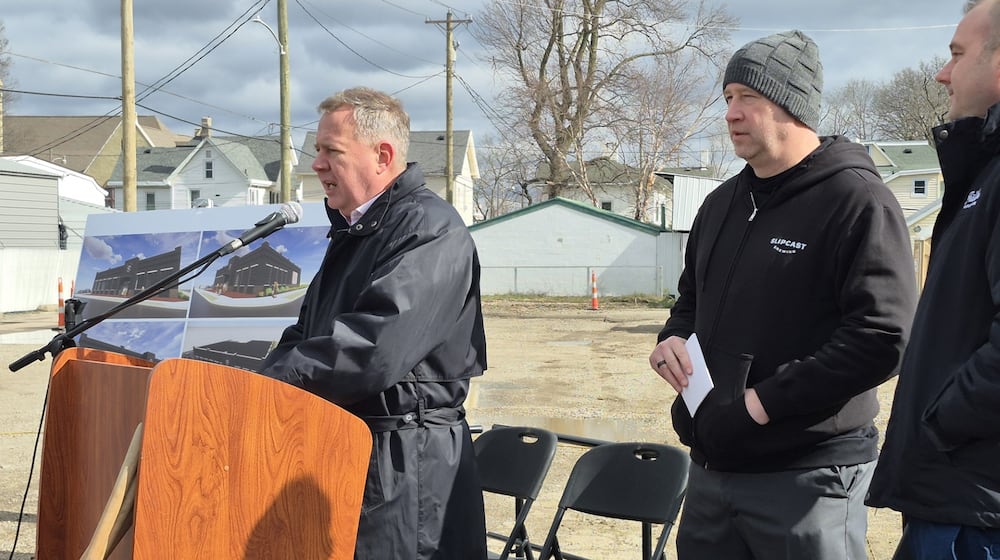 From left, Franklin City Manager Jonathan Westendorf, owner Brian Willett, and Mayor Brent Centers address a crowd at the future site of Slipcast Brewery. MICHAEL KURTZ / STAFF