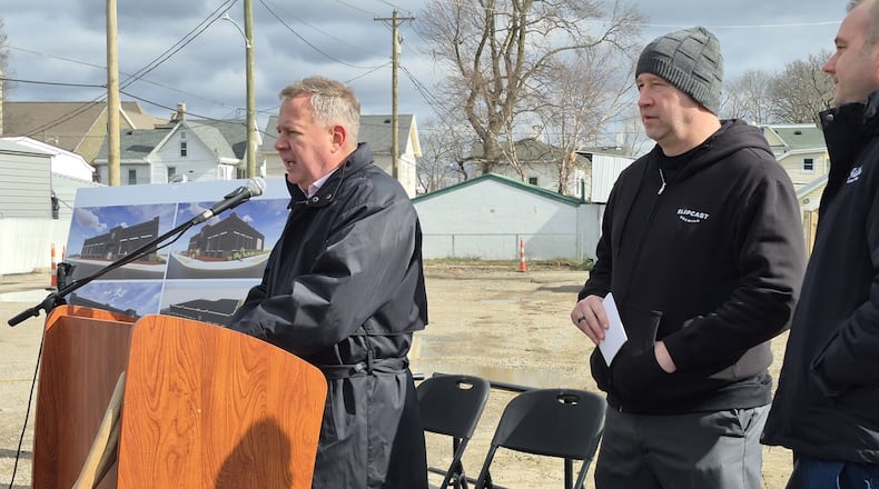 From left, Franklin City Manager Jonathan Westendorf, owner Brian Willett, and Mayor Brent Centers address a crowd at the future site of Slipcast Brewery. MICHAEL KURTZ / STAFF