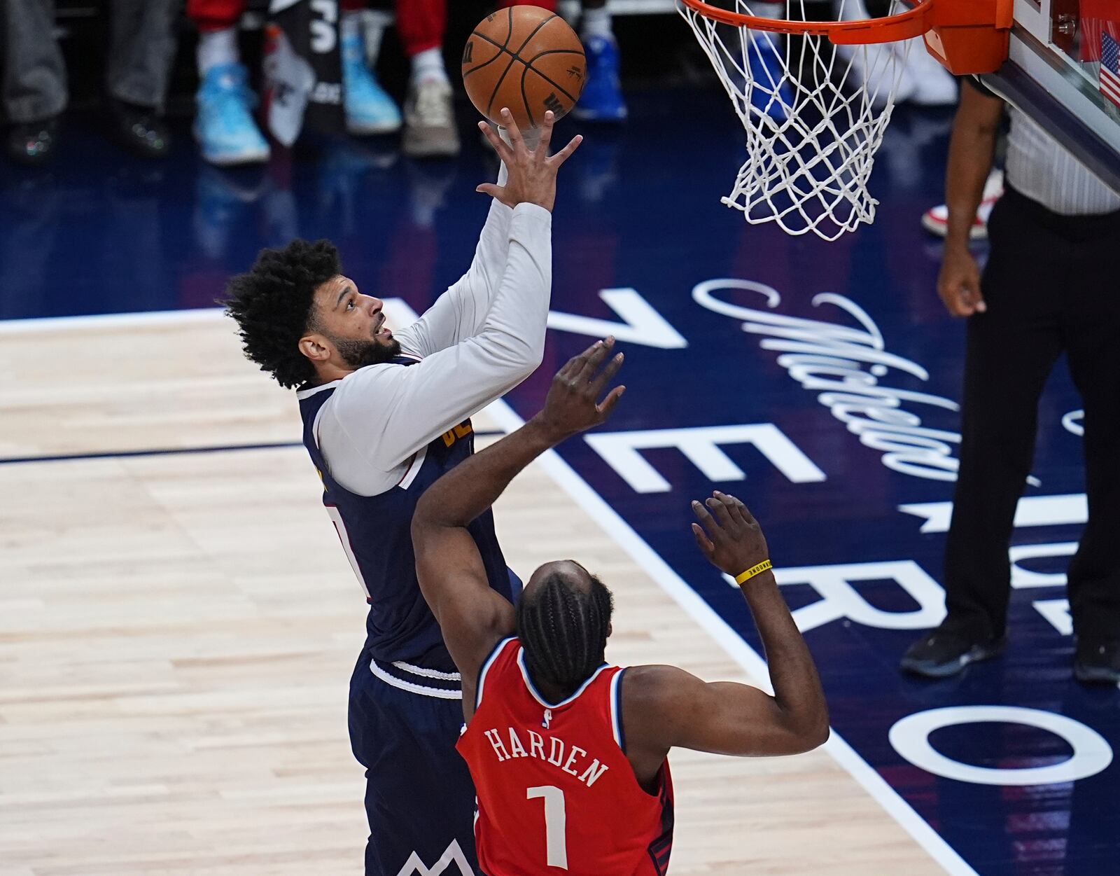 Denver Nuggets guard Jamal Murray, top, drives to the basket as Los Angeles Clippers guard James Harden, bottom, defends in the first half of Game 2 of a first-round NBA playoff series Monday, April 21, 2025, in Denver. (AP Photo/David Zalubowski)