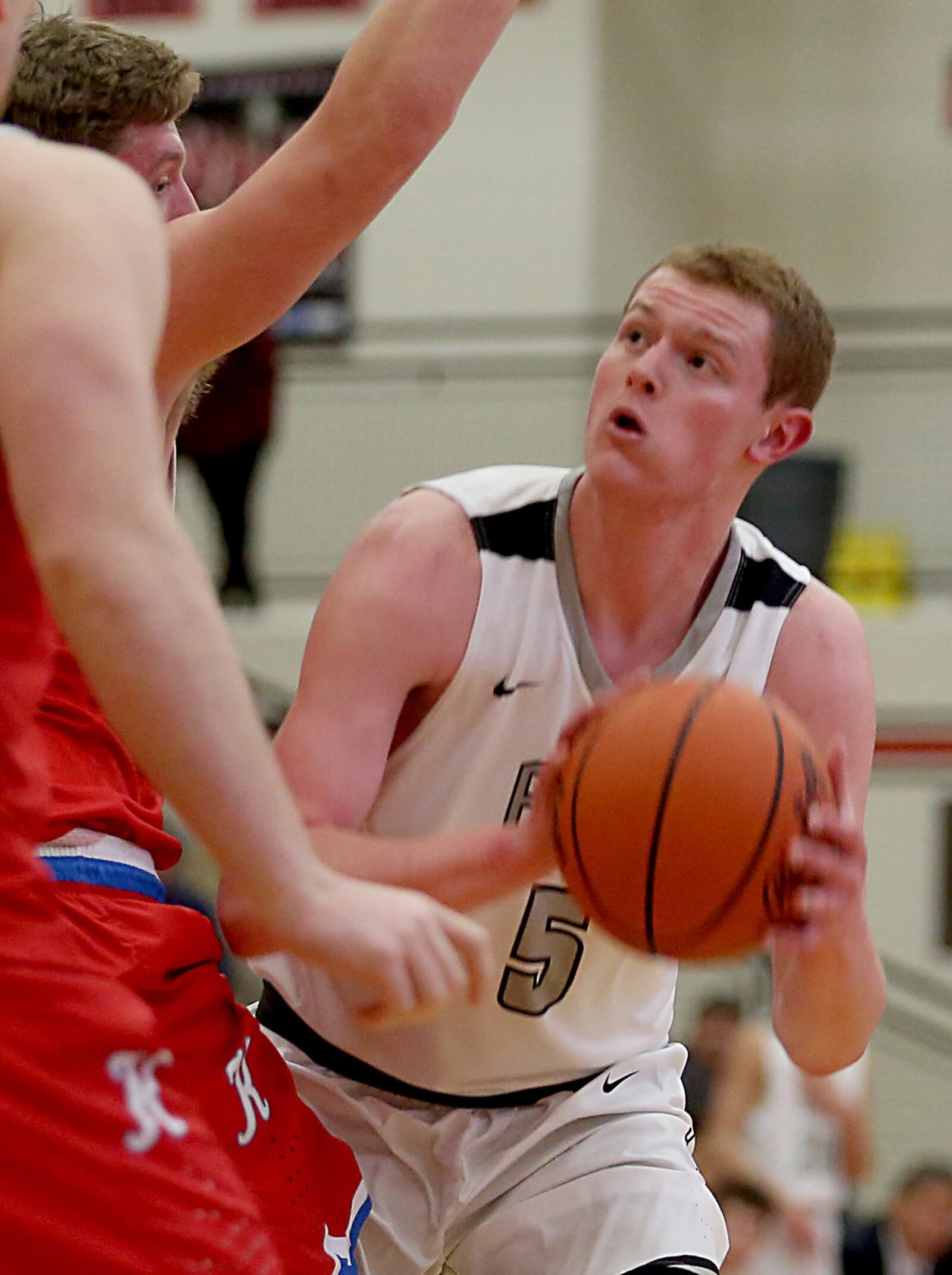 Lakota East forward Evan Kuhlman eyes the hoop before scoring on Kings forward Dan Sichterman during their Division I sectional game at Lakota West on March 1. CONTRIBUTED PHOTO BY E.L. HUBBARD