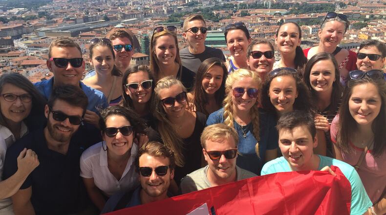 R. Darden Bradshaw (upper right in red sweater with sunglasses on her head) stands with University of Dayton students and instructor Laura Hume (far left) atop the Santa Maria del Fiore Cathedral in Florence, Italy, during a five-week interdisciplinary course last summer. CONTRIBUTED