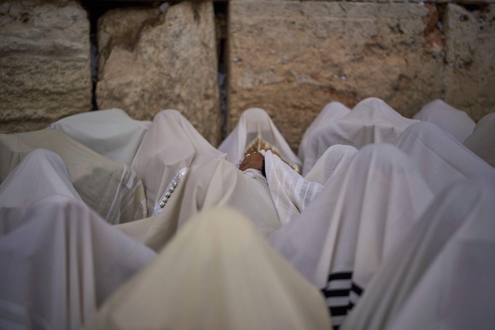 Covered in prayer shawls, Jewish men of the Cohanim Priestly caste participate in a blessing during the holiday of Passover, at the Western Wall, the holiest site where Jews can pray, in the Old City of Jerusalem, Tuesday, April 15, 2025. (AP Photo/Leo Correa)