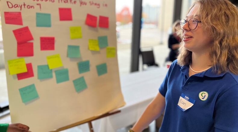 Micah Rambo, a 15-year-old sophomore at Chaminade Julienne Catholic High School, posted a sticky note with the word "community" on a board that asked, "What would make you stay in Dayton?" CORNELIUS FROLIK / STAFF