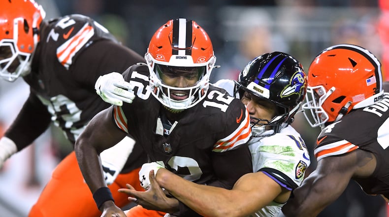 Cleveland Browns quarterback Shedeur Sanders (12) is sacked by Baltimore Ravens safety Kyle Hamilton (14) in the second half of an NFL football game in Cleveland, Sunday, Nov. 16, 2025. (AP Photo/David Richard)