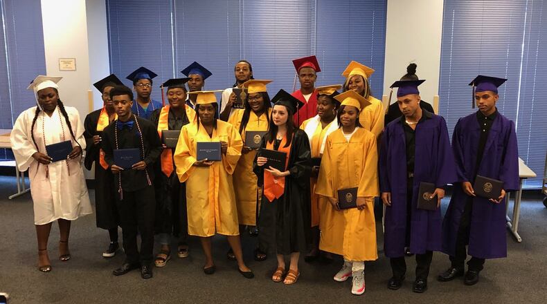 Seventeen of Dayton Public Schools’ 2019 summer graduates received their high school diplomas in front of their families at a school board meeting. JEREMY P. KELLEY / STAFF