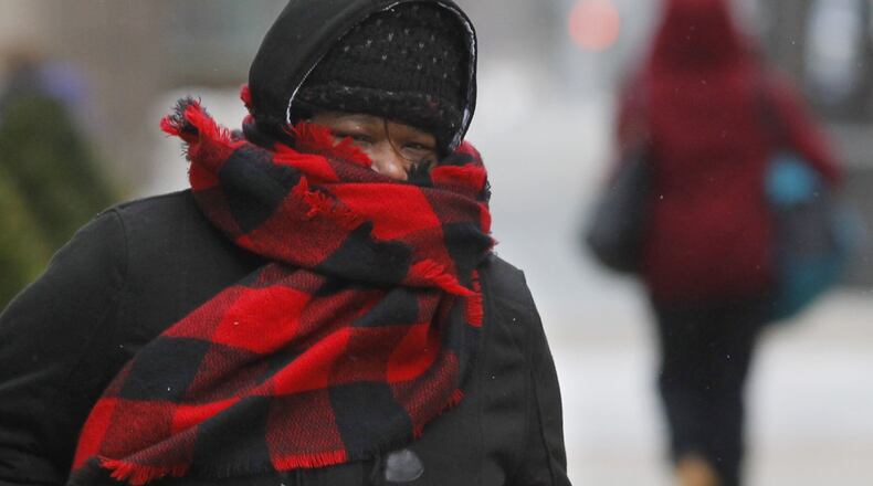 Laquita Curry was bundled up for her walk to work in downtown Dayton on Tuesday morning and said she plans to be more prepared for Wednesday’s sub-zero temperatures. TY GREENLEES / STAFF