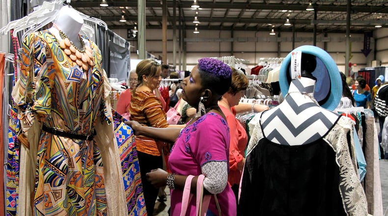 Rhonda Faye of Dayton browses through clothing at the Dayton Women's Fair which kicked off Saturday at the Airport Expo Center in Vandalia. The event, which features local and regions merchants, food, fashion and fun, continues Sunday from 10 a.m. to 5 p.m. LISA POWELL / STAFF PHOTO