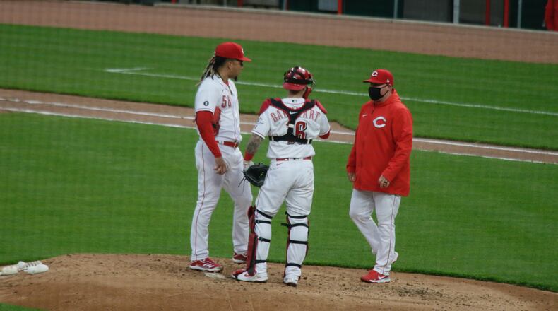 Reds starter Luis Castillo, catcher Tucker Barnhart and pitching coach Derek Johnson meet on the mound during a game against the Diamondbacks on Tuesday, April 20, 2021, at Great American Ball Park in Cincinnati. David Jablonski/Staff