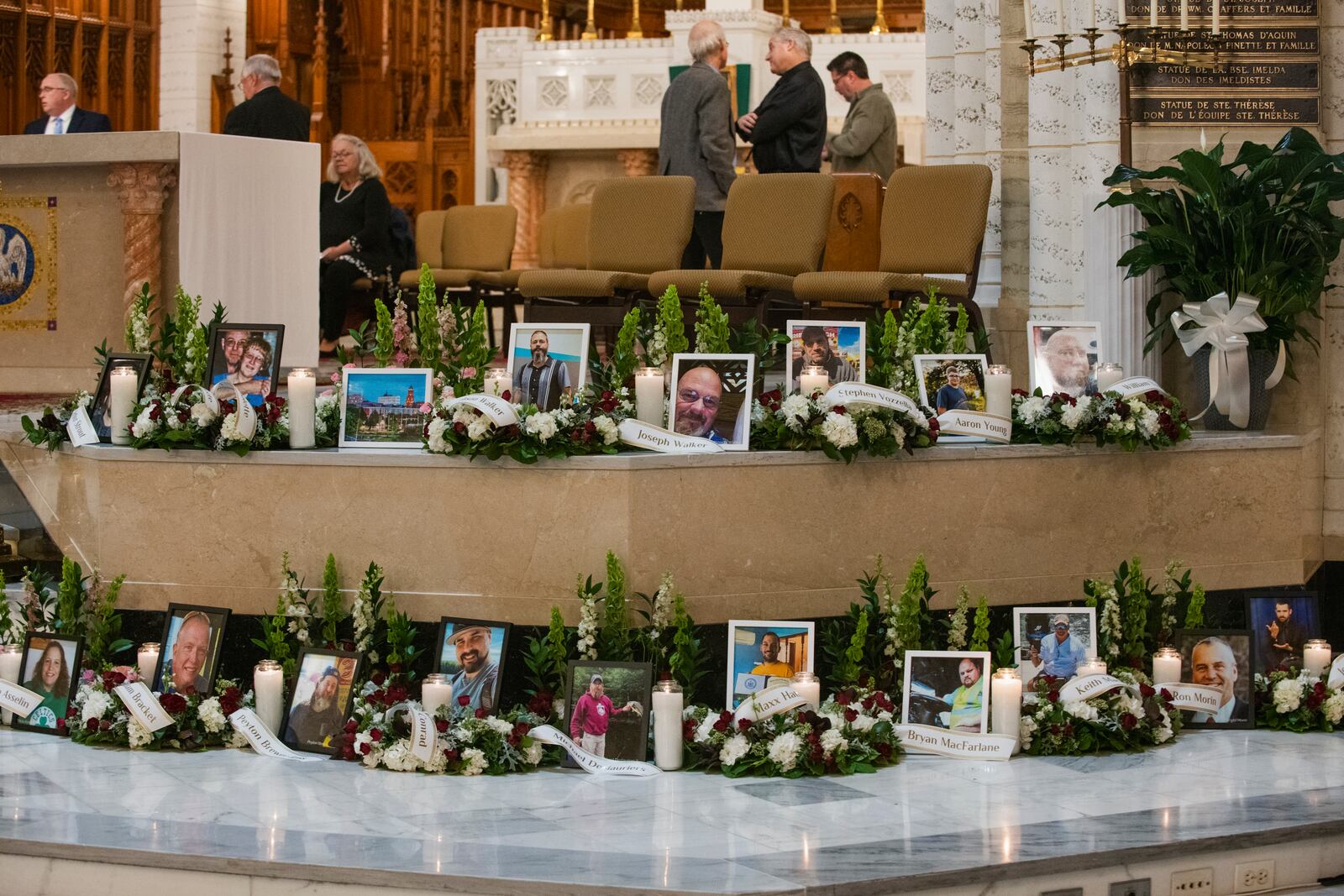
                        Photos of the 18 people who were killed in the Lewiston mass shooting are displayed during a memorial service at Holy Family Church in Lewiston, Maine, Oct. 29, 2023. Residents in and around the city, no longer under lockdowns, spent the weekend coming together to mourn, share meals and prepare to bury their dead. (Andrew Cullen/The New York Times)
                      