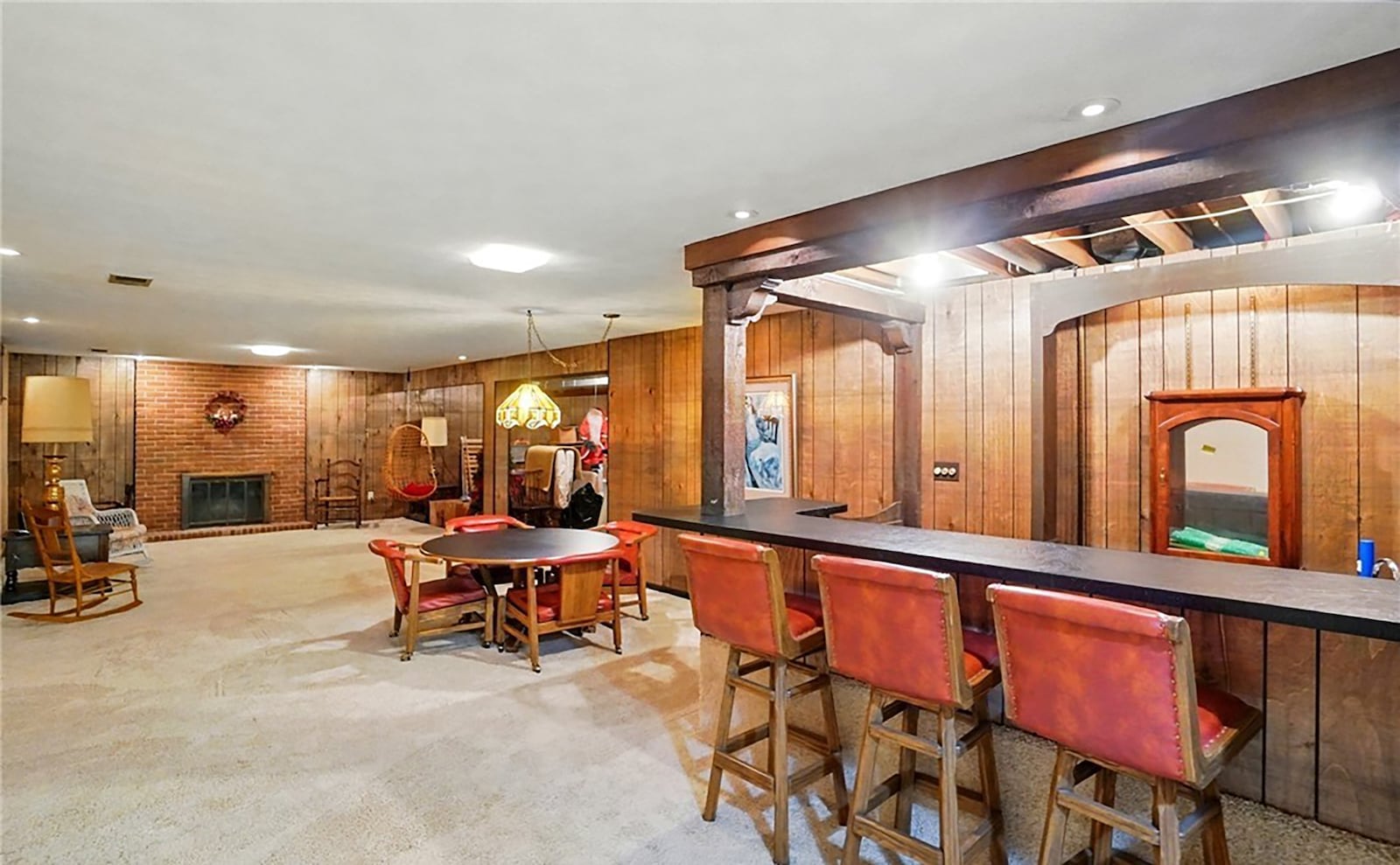 The finished basement has a recreation room with a woodburning fireplace and an original wet bar with seating area.