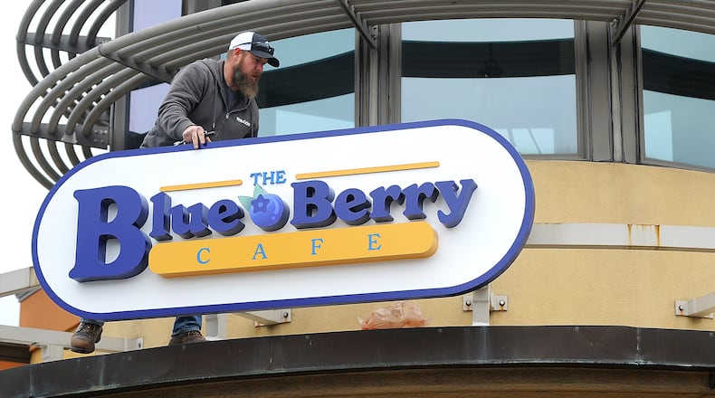 Marc Robinson of Wilcon Construction places The Blue Berry Cafe sign on the old Golden Nuggent Pancake House in Kettering Wednesday, Jan. 3, 2024. MARSHALL GORBY\STAFF