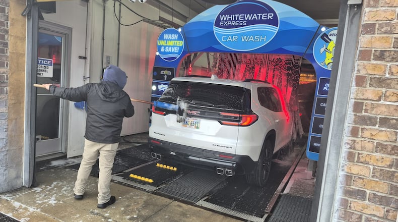An attendant applies soap to a vehicle at Springboro WhiteWater Express Car Wash. Drivers are flocking to car washes as the weather warms. MICHAEL KURTZ / STAFF