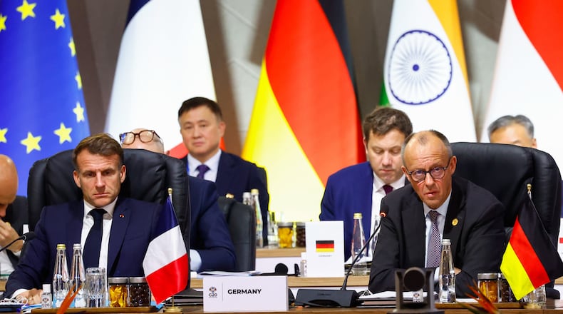 France's President Emmanuel Macron and Germany's Chancellor Friedrich Merz attend a plenary session on the opening day of the G20 Summit at the Nasrec Expo Centre, in Johannesburg, South Africa, Saturday, Nov. 22, 2025. (Thomas Mukoya/Pool Photo via AP)