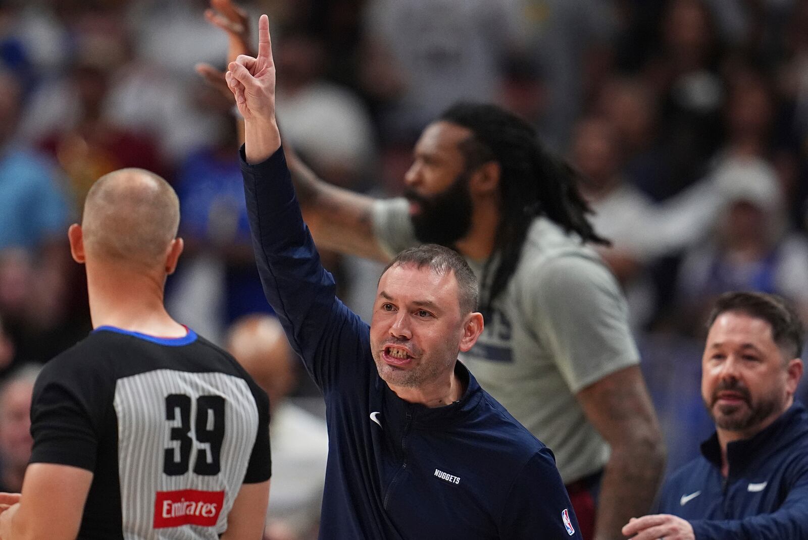 Denver Nuggets interim head coach David Adelman, center, argues for a call with referee Tyler Ford, left, as Nuggets trainer Dan Shimensky, right, comes over to stop him in the first half of Game 4 in the Western Conference semifinals of the NBA basketball playoffs against the Oklahoma City Thunder, Sunday, May 11, 2025, in Denver. (AP Photo/David Zalubowski)