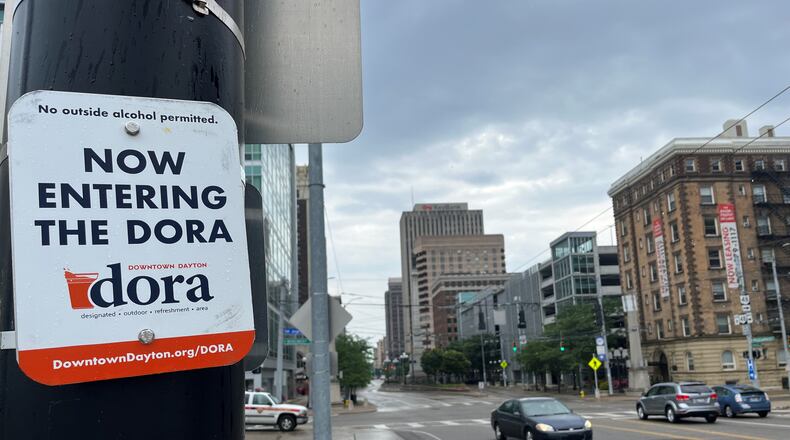 A sign on North Main Street at the edge of the new downtown Dayton Designated Outdoor Refreshment Area (DORA). The new DORA covers most of downtown. Inside the DORA boundaries, people can buy and drink alcohol in special to-go cups on the street. CORNELIUS FROLIK / STAFF