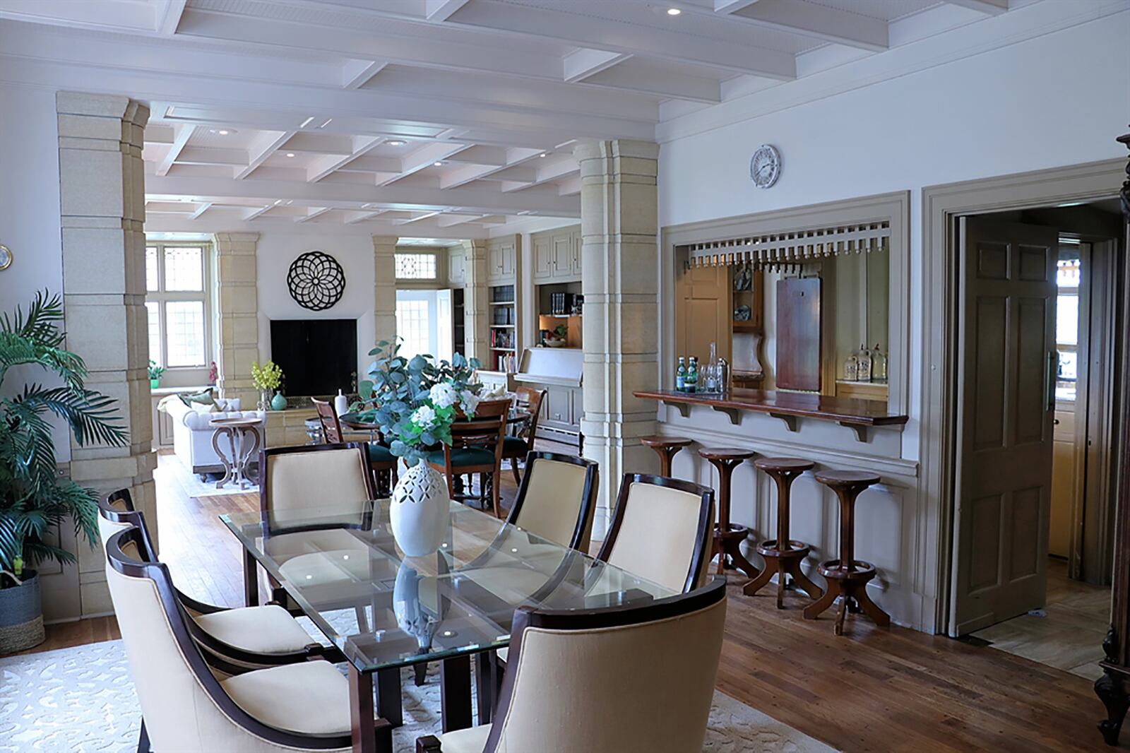 An open social space that flows from the formal dining area to a great room seating area to a pass-through gated bar has several box windows with seats and leaded-glass patio doors that open out to a large outdoor patio. CONTRIBUTED PHOTO BY KATHY TYLER