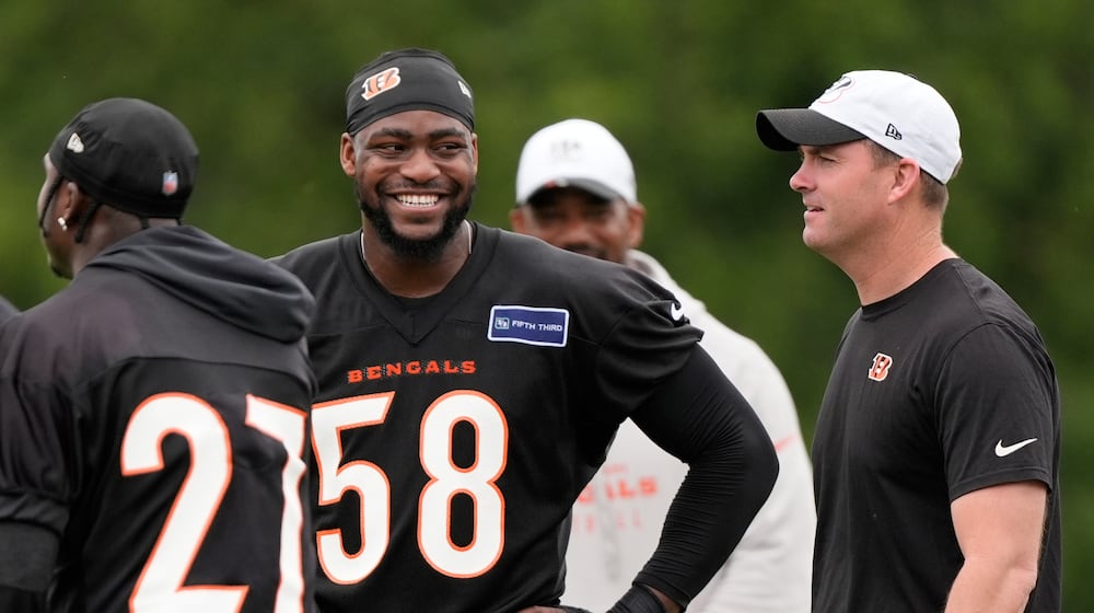 Cincinnati Bengals defensive end Joseph Ossai (58) smiles at Cincinnati Bengals head coarch Zac Taylor, right, during NFL football practice on Tuesday, May 13, 2025, in Cincinnati. Cincinnati Bengals safety Jordan Battle (27) is also seen. (AP Photo/Carolyn Kaster)