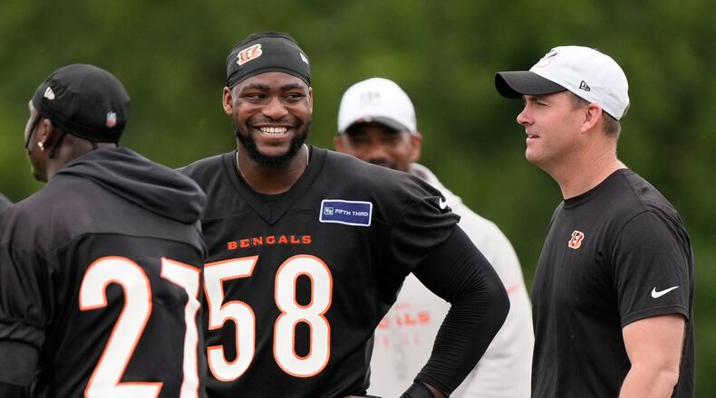 Cincinnati Bengals defensive end Joseph Ossai (58) smiles at Cincinnati Bengals head coarch Zac Taylor, right, during NFL football practice on Tuesday, May 13, 2025, in Cincinnati. Cincinnati Bengals safety Jordan Battle (27) is also seen. (AP Photo/Carolyn Kaster)