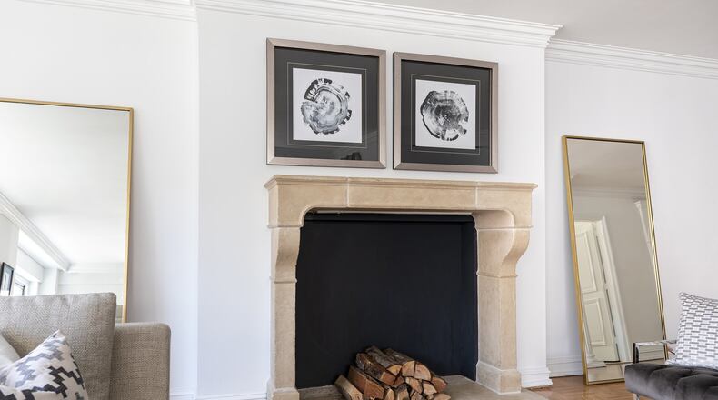 A pair of hung art pieces and leaning mirrors help fram a fireplace mantel. (Design Recipes)