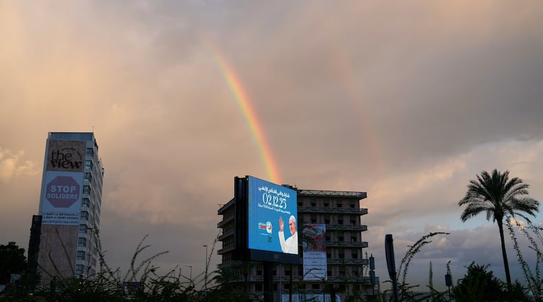 A rainbow rises behind a billboard featuring Pope Leo XIV in Beirut, Lebanon, Monday, Dec. 1, 2025. (AP Photo/Hassan Ammar)