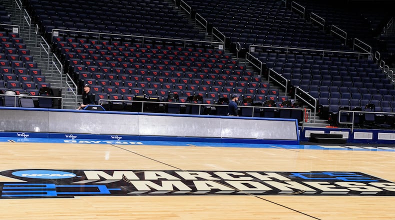 On St. Patrick's Day 2024, workers put the finishing touches on the basketball court installation for the First Four of the NCAA Division I Men’s Basketball Championship at UD Arena which will take place on March 19 & 20, 2024. TOM GILLIAM / CONTRIBUTING PHOTOGRAPHER