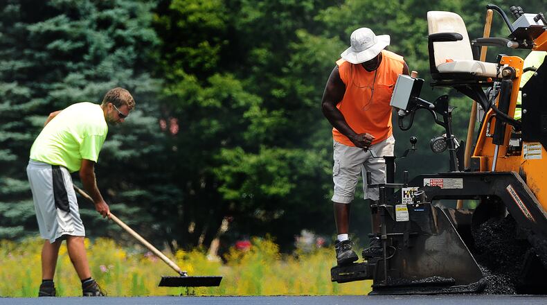 Even with temperatures in the 90s on Wednesday, July 26, 2023, workers were laying asphalt at Thomas A. Cloud Park in Huber Heights. MARSHALL GORBY\STAFF