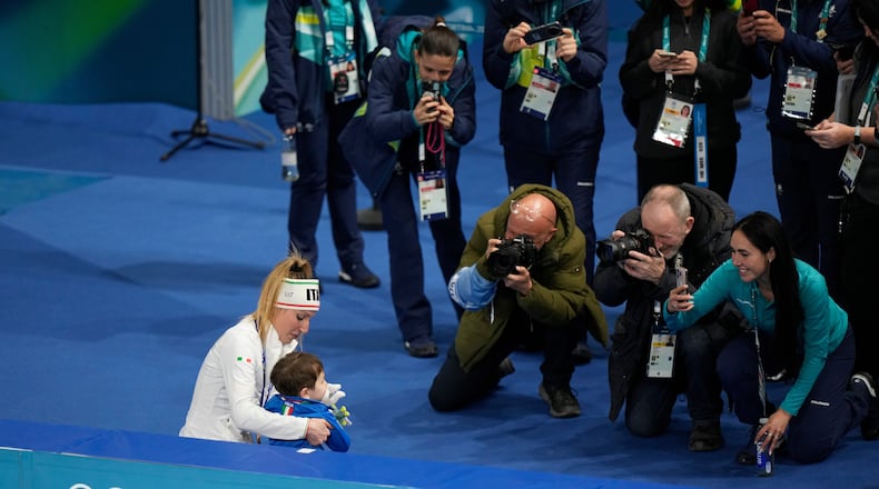 Francesca Lollobrigida of Italy celebrates with her son Tommaso after winning the gold medal in the women's 3,000 meters speedskating race at the 2026 Winter Olympics, in Milan, Italy, Saturday, Feb. 7, 2026. (AP Photo/Luca Bruno)
