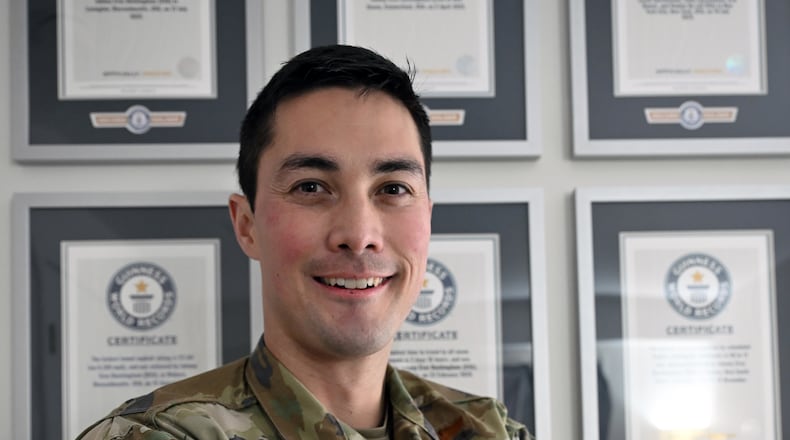 Maj. Jonathan Buckingham poses in front of a wall of Guinness World Records he achieved, Feb. 4, 2026. Buckingham set 17 Guinness World Records and has three submissions pending review. (U.S. Air Force Photo by Richard Blumenstein)