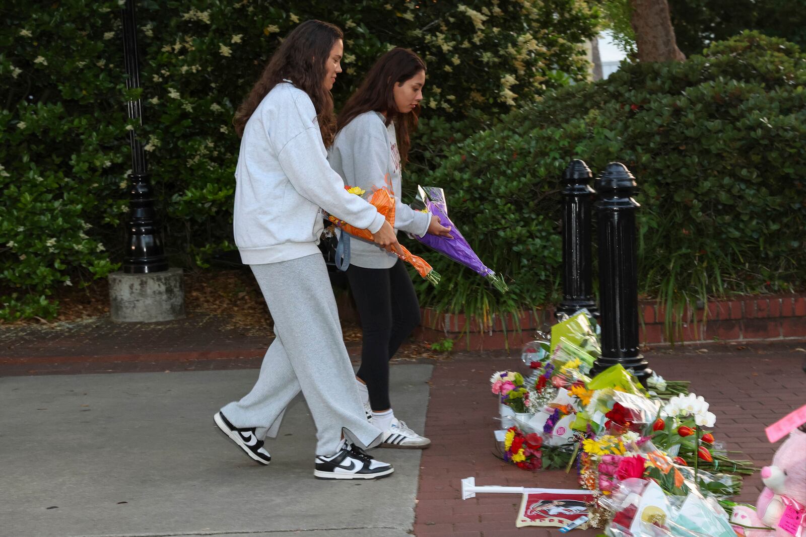An impromptu memorial shared online brings students bearing flowers near the center of the Florida State campus in sight of the Student Union building, Tallahassee, Fla., Thursday, April 17, 2025. (AP Photo/Gary McCullough)