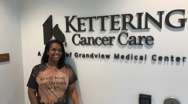 Amber Treadwell, a local breast cancer survivor, standing in front of the Kettering Cancer Care sign.
