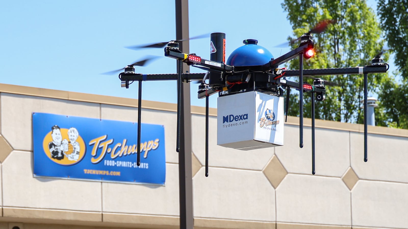 A drone operated by DEXA prepares to drops a test delivery during a demonstration on Wednesday, July 23 at TJ Chumps in Kettering. The drone flies at 400 feet during transit and drops to about 10 feet, then lowers the food delivery to the ground with a cable. BRYANT BILLING / STAFF