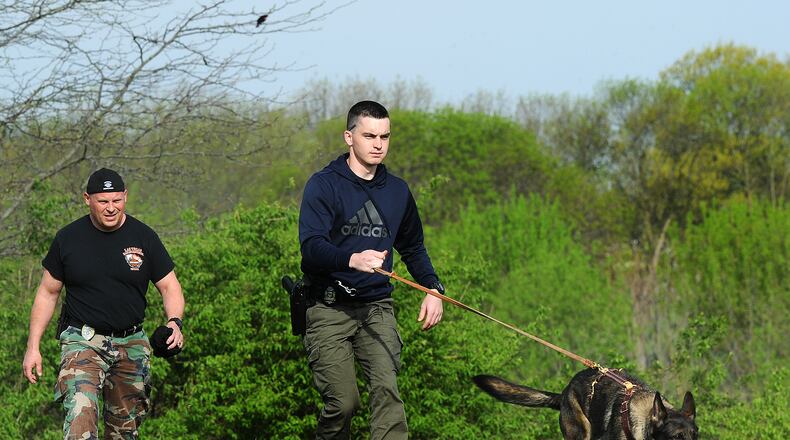 Franklin police Officer Olen Keil follows K-9 Liza following a ground scent during a tracking exercise in Kettering on Thursday. Kettering police Lt. Brad Lampert, left, evaluates how the K-9 team is doing as it tracks down the dog's toy. Kettering police is training several K-9s in the area for free so that there is a standardized level of training for the dogs and handlers. The 12-week course ends June 30 with an evaluation by the Ohio Peace Officers Training Academy. If they pass the evaluation, the dog will receive state K-9 certification. MARSHALL GORBY\STAFF