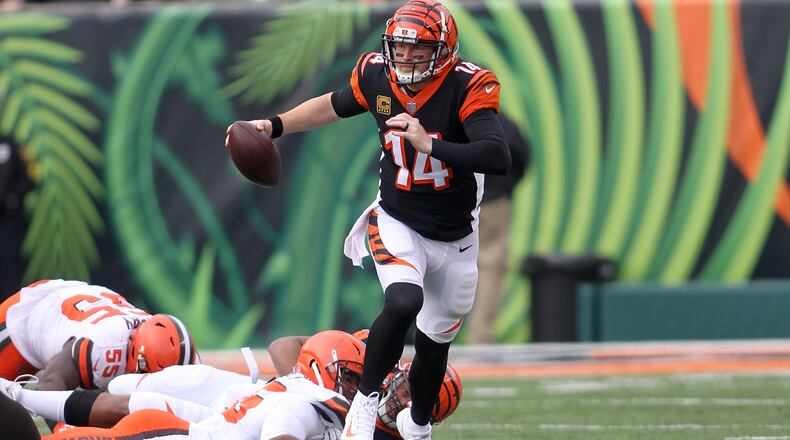 CINCINNATI, OH - NOVEMBER 25: Andy Dalton #14 of the Cincinnati Bengals slips out of an attempted tackle by Myles Garrett #95 of the Cleveland Browns during the second quarter at Paul Brown Stadium on November 25, 2018 in Cincinnati, Ohio. (Photo by John Grieshop/Getty Images)