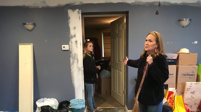 Julia Stewart of Beavercreek and her 11-year-old daughter Averi show the finished garage space their family is moving into while they fight with insurance over repairs to the rest of the house.