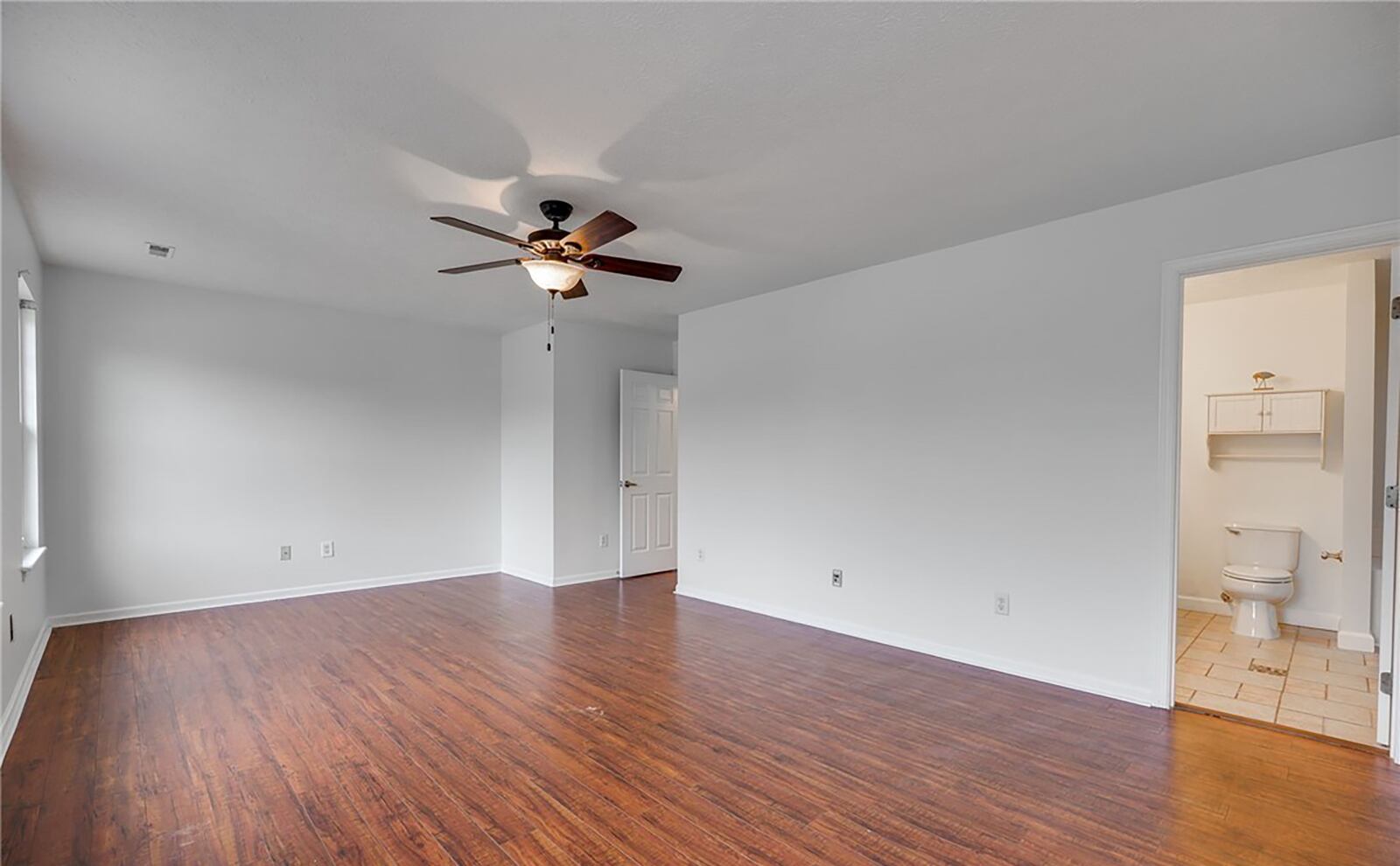 The second level primary suite has hardwood floors, a ceiling fan and ensuite bathroom with jetted soaking tub and walk in closet with organizer.