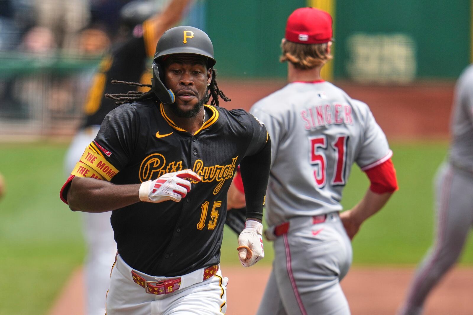 Pittsburgh Pirates' Oneil Cruz (15) scores from third on a sacrifice fly by Bryan Reynolds off Cincinnati Reds pitcher Brady Singer (51) during the first inning of a baseball game in Pittsburgh, Wednesday, May 21, 2025. (AP Photo/Gene J. Puskar)
