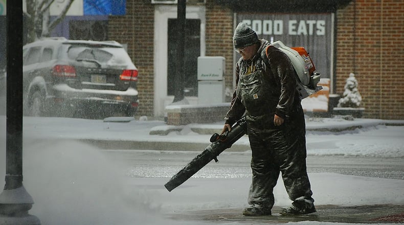 City of Fairborn crews blow snow off the sidewalks at Main Street and Central Aveneu early Friday morning, January 19, 2024.. MARSHALL GORBY \STAFF