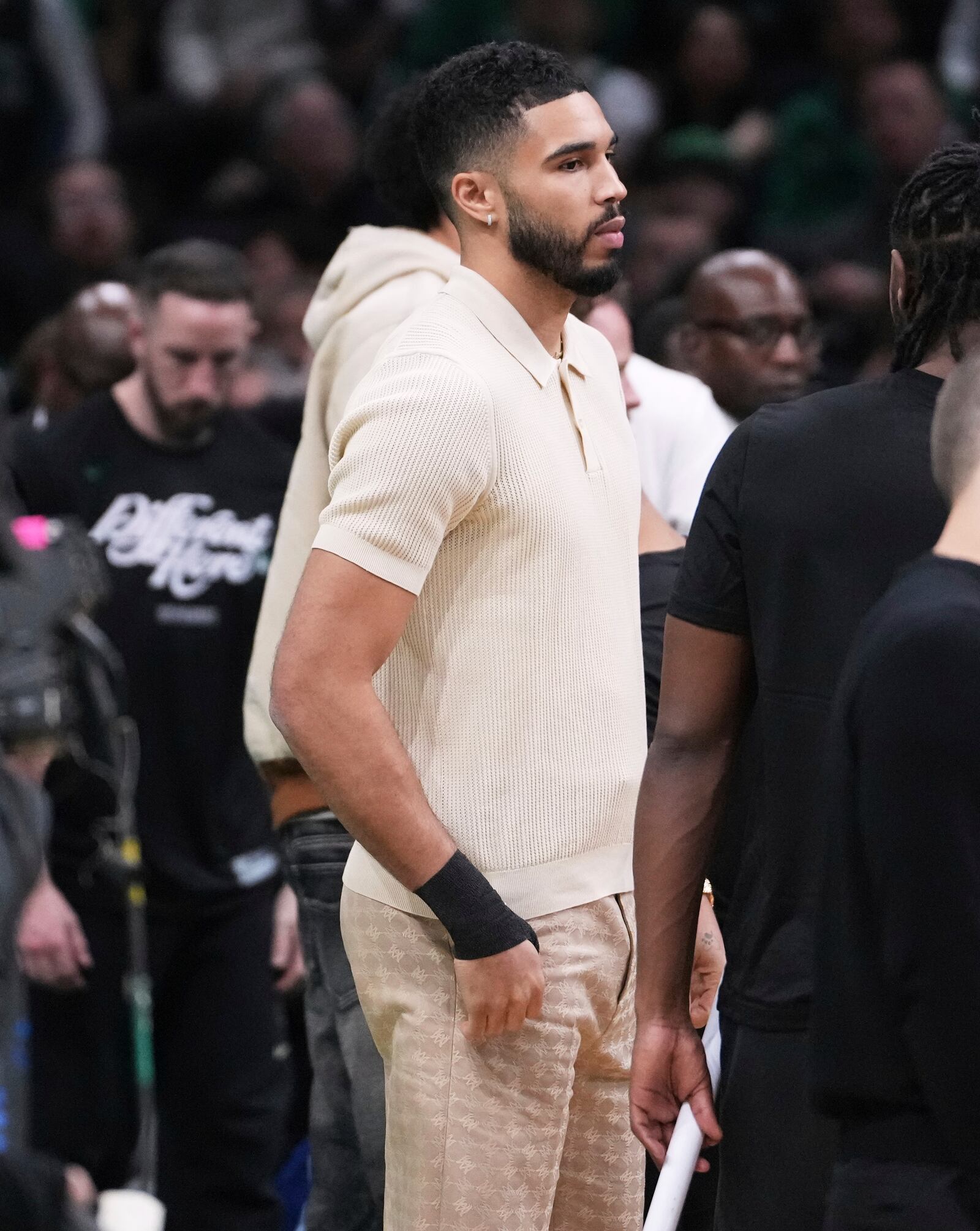 Boston Celtics forward Jayson Tatum, who is sidelined with an injury, stands near the bench with his wrist wrapped during the first half in game 2 of a first-round NBA playoff basketball series against the Orlando Magic, Wednesday, April 23, 2025, in Boston. (AP Photo/Charles Krupa)