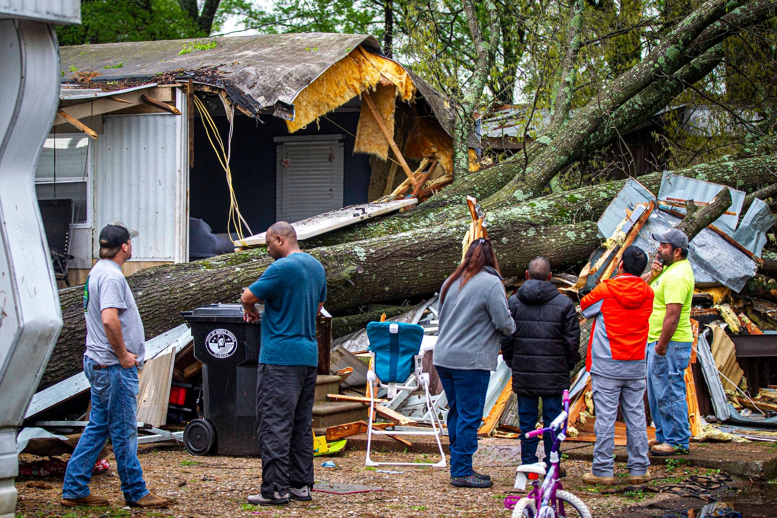 A group of people survey damage at Pounders Mobile Home Park following a strong line of storms in the area in Muscle Shoals, Ala, Sunday, April 6, 2025. (Dan Busey/The TimesDaily via AP)