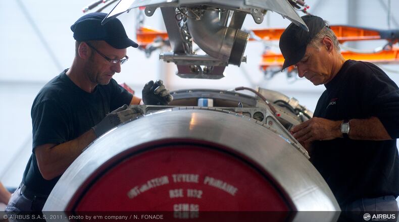 A file photo of workers with a CFM56 engine built by CFM International. The engine was being readied for installation on the A320 final assembly line at a Airbus factory. FILE