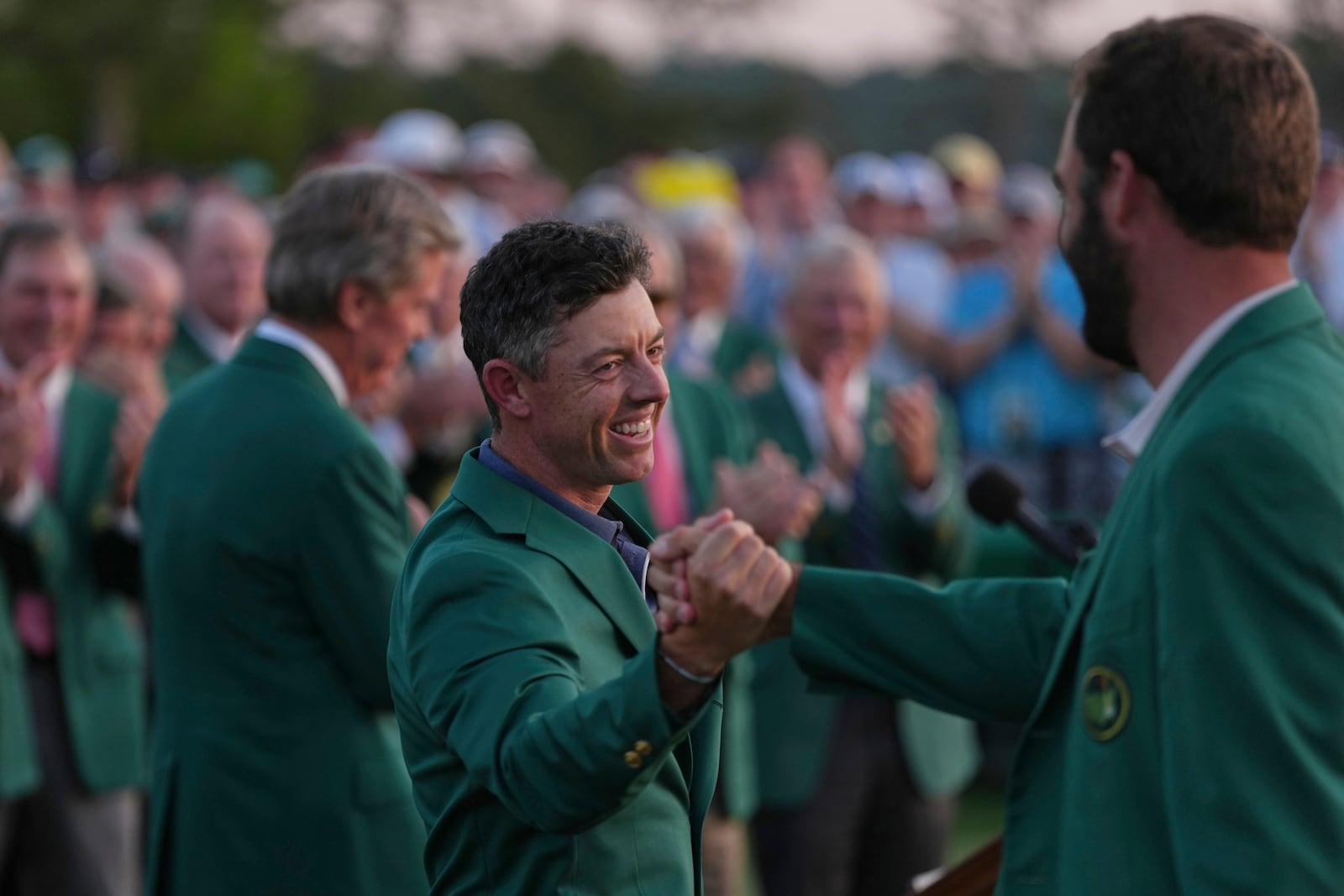 Defending champion Scottie Scheffler, right, greets winner Rory McIlroy, of Northern Ireland, at the Masters golf tournament, Sunday, April 13, 2025, in Augusta, Ga. (AP Photo/Matt Slocum)