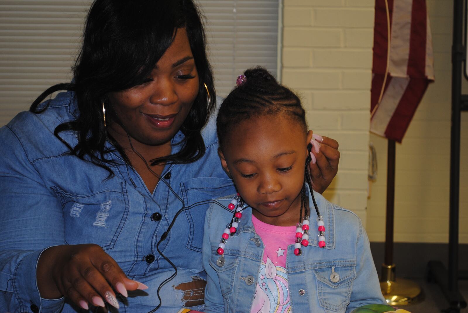 Alyce Littlebear and her four year old daughter Mia at the Dayton Public Library in Trotwood listening to Mia's daddy Avery Farley read stories from the Green County Jail. (CONTRIBUTED)