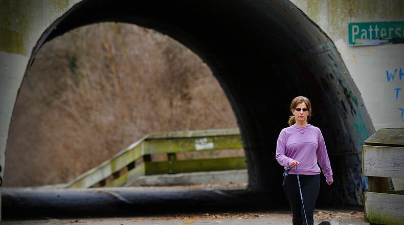 FILE PHOTO: Keren Ray walks her dog, Coco, on the bike path near Oakwood, on a warm Monday February 21, 2022. MARSHALL GORBY\STAFF