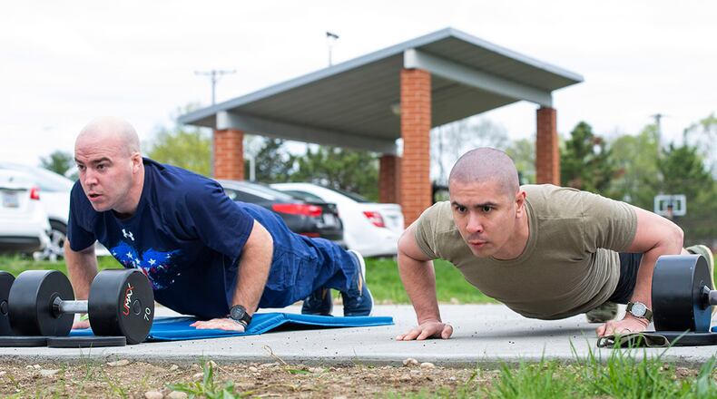 Airman 1st Class Michael Mannozzi (left), 88th Air Base Wing chaplain’s assistant, and Staff Sgt. Ronald Knox, Air Force Institute of Technology knowledge operator, do as many pushups as they can in a one-minute period during the All-Star Fitness Challenge at Wright-Patterson Air Force Base on April 15. Competitors had to do a series of exercises at four different stations. U.S. AIR FORCE PHOTO/WESLEY FARNSWORTH