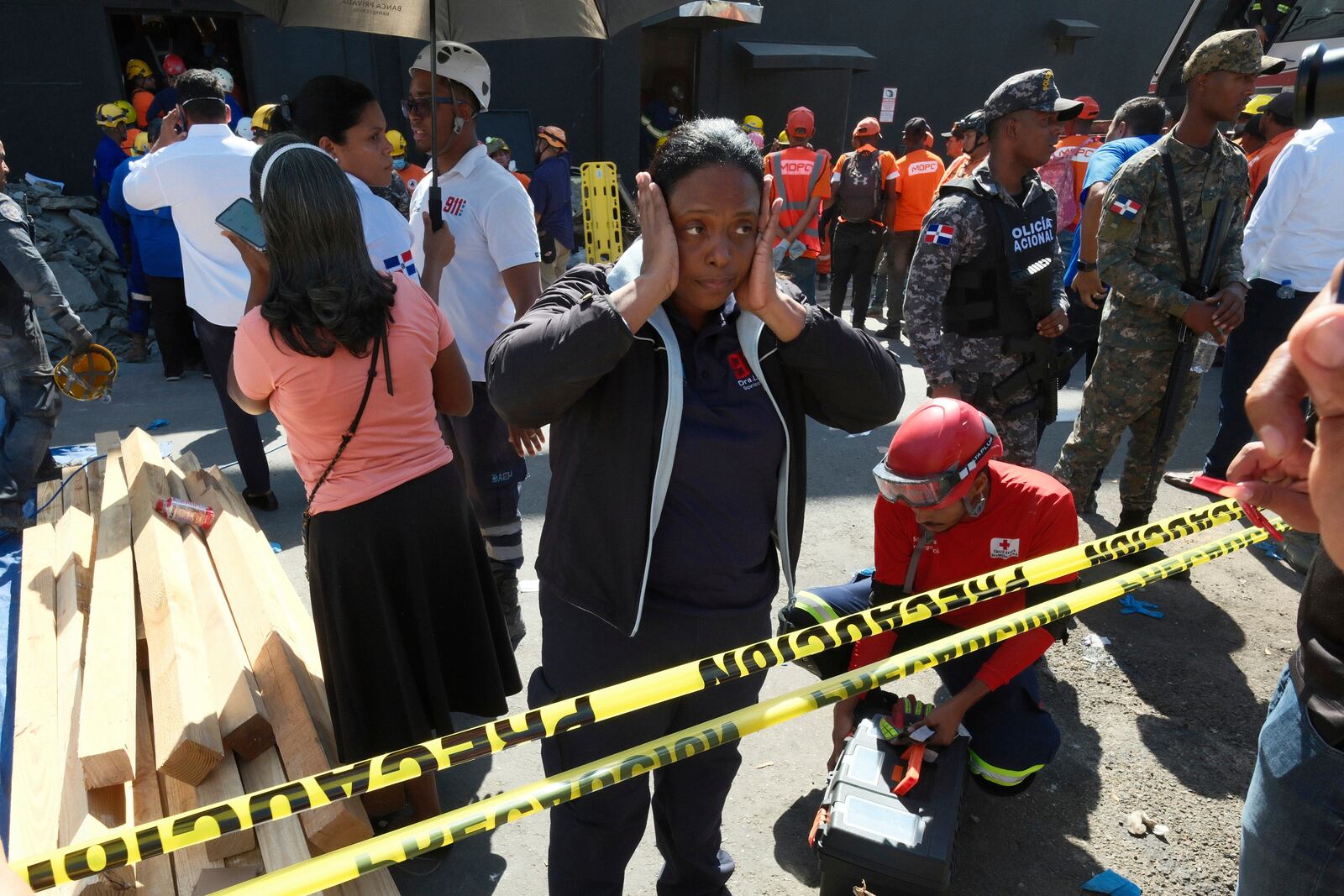 A woman stands outside the Jet Set nightclub after its roof collapsed during a merengue concert in Santo Domingo, Dominican Republic, Tuesday, April 8, 2025. (AP Photo/Ricardo Hernandez)
