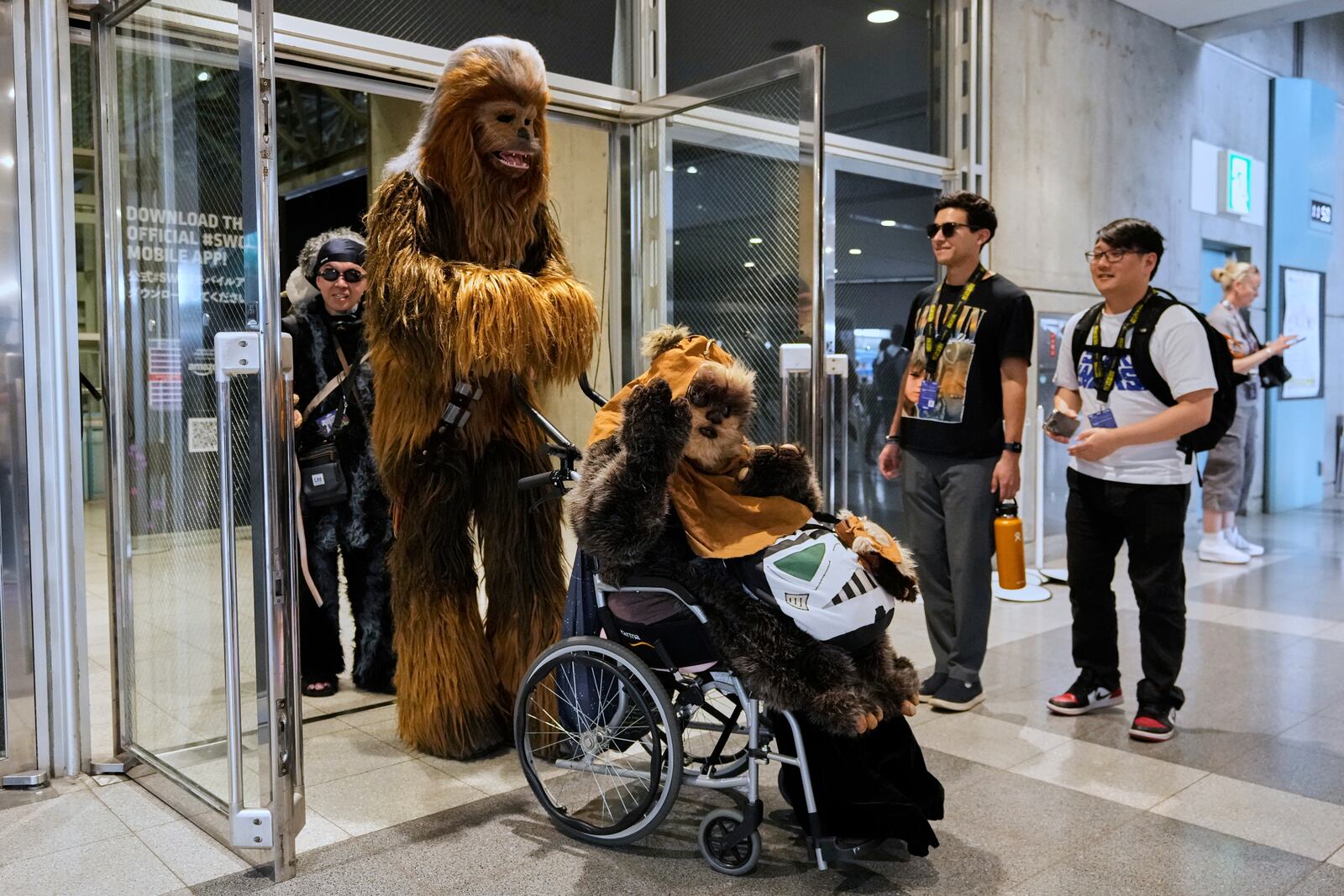 Star Wars fans wearing costumes of Chewbacca, left, and Widdle Warrick pose for a photo during a fan convention called the Star Wars Celebration in Chiba, near Tokyo, Friday, April 18, 2025. (AP Photo/Hiro Komae)