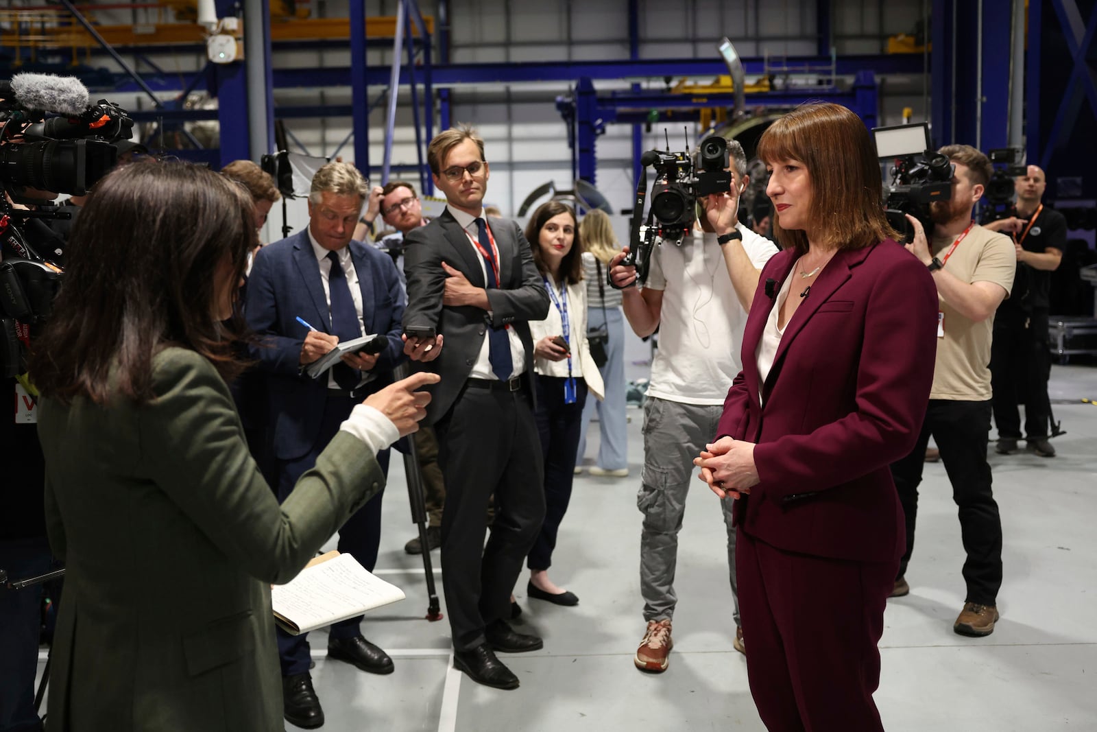 Britain's Chancellor of the Exchequer Rachel Reeves, right, speaks with the media at the Rolls-Royce factory in Derby, England following the announcement from the Office for National Statistics that the U.K. economy grew by 0.7% between January and March, Thursday, May 15, 2025. (Darren Staples/PA via AP)